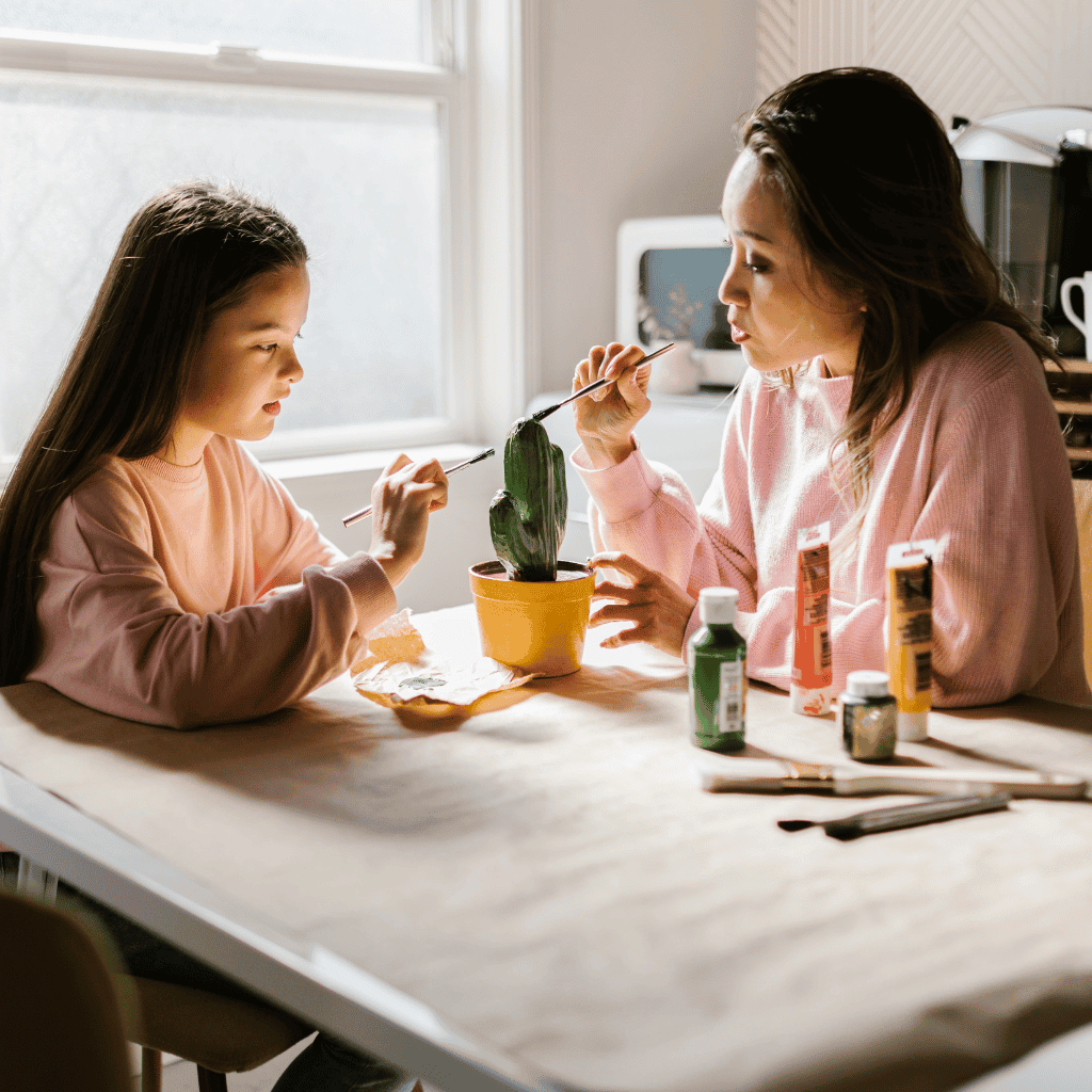 Woman and girl painting a cactus together